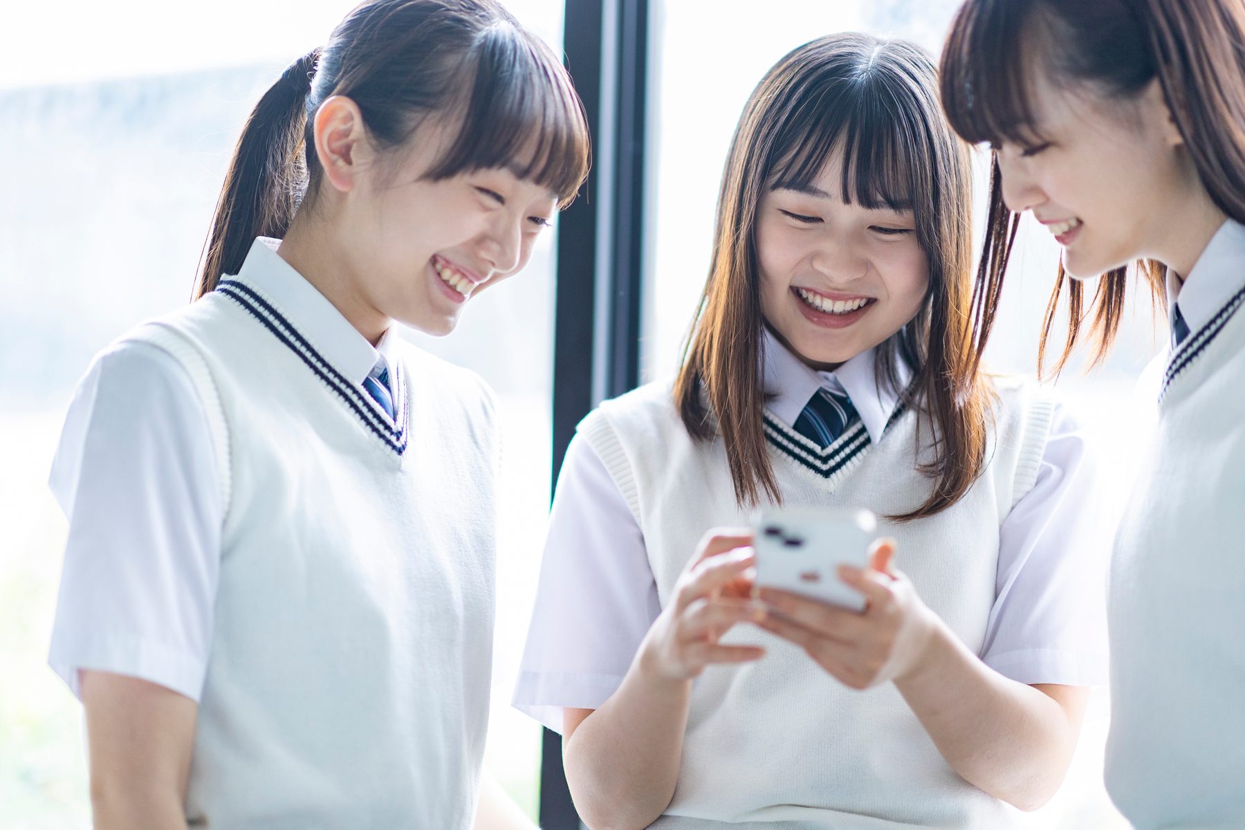 スマホで一緒に問題を見る高校生たち