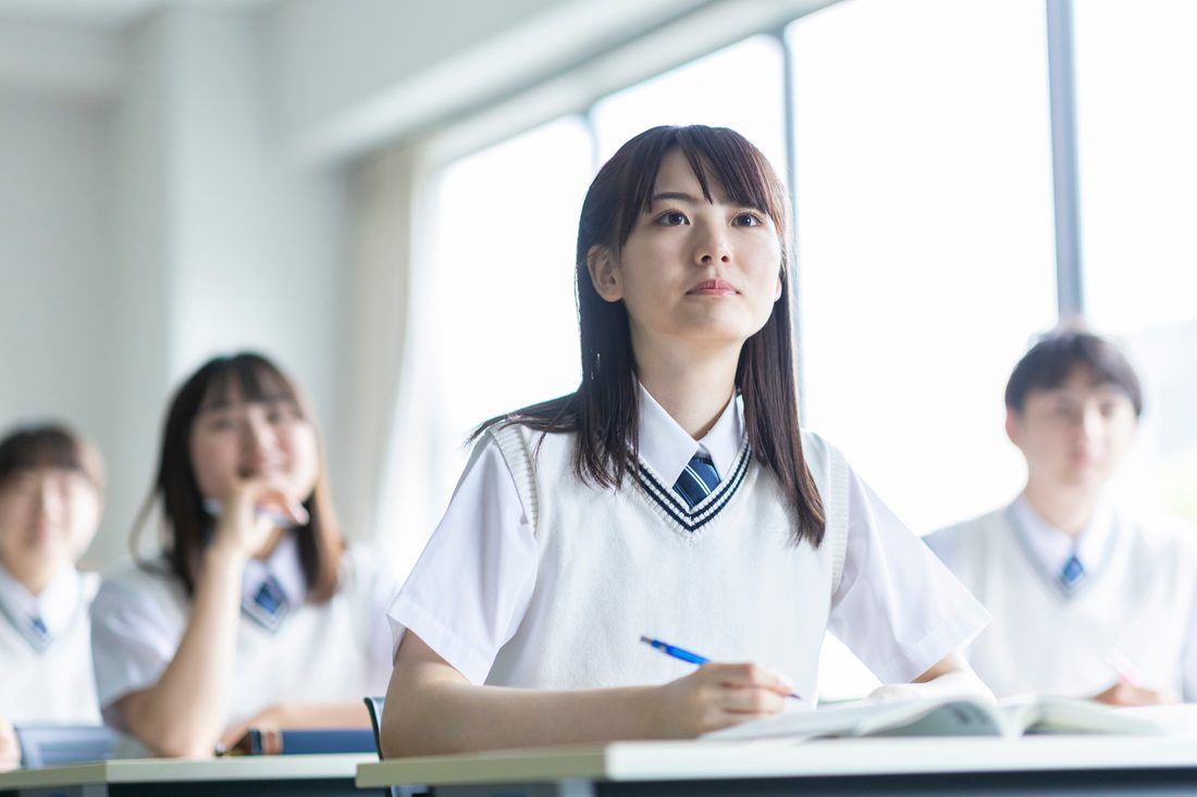 机に向かって問題を解く高校生