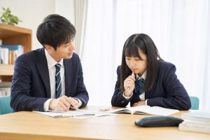 講師が高校生に一対一で学習計画を説明している個別指導の様子